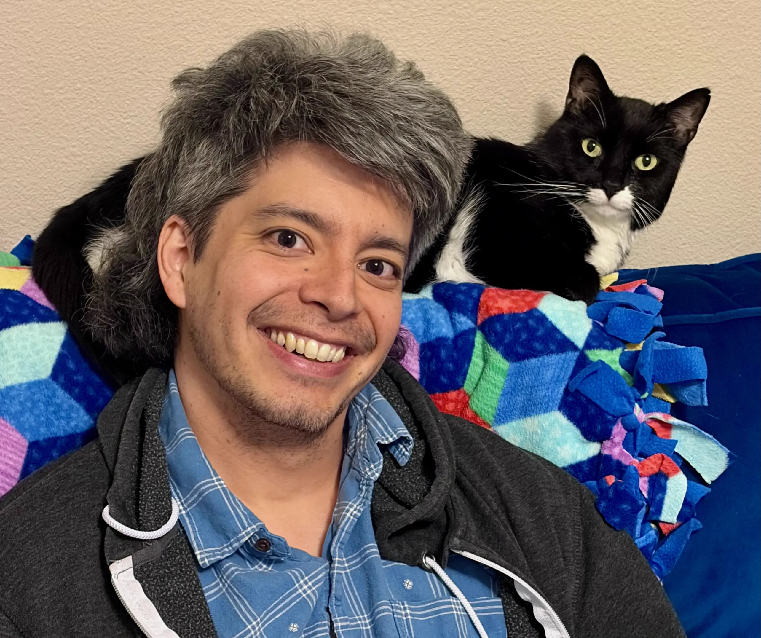 Erik smiling with a cat on his shoulder